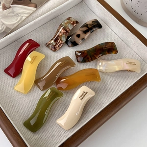 Detail of wavy acetate hair clips in various patterns with France Handmade gold engraving