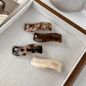 Detailed set of four wavy acetate hair clips with amber and tortoiseshell patterns