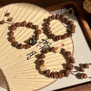 Bracelets grains de café tissés avec pendentifs patte de chat sur un éventail