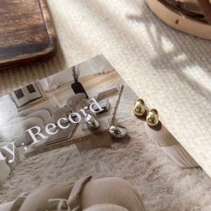 Minimalist bean-shaped metal stud earrings in gold and silver finish with mirror luster