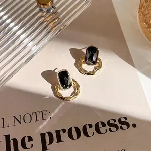 Boucles d'oreilles rétro géométriques avec pierre noire et fini en métal doré texturé