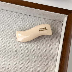Macro shot of wavy acetate hair clip showing the France Handmade craft detail