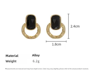 Vue détaillée des boucles d'oreilles géométriques avec pierre noire et anneau martelé