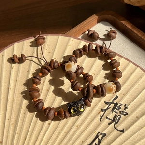 Gros plan détaillé de bracelets en grains de café avec breloques de patte de chat