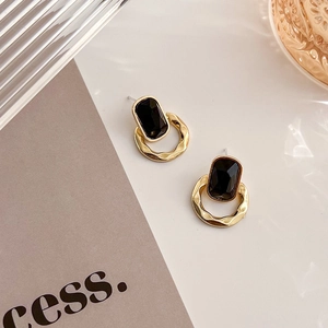 Vue détaillée des boucles d'oreilles carrées avec pierre noire et fini doré texturé