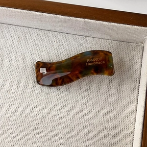 Detail of wavy tortoiseshell hair clip showing glossy finish and France Handmade text