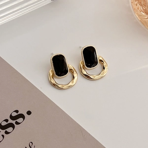 Détails de boucles d'oreilles géométriques dorées avec pierres noires de style rétro