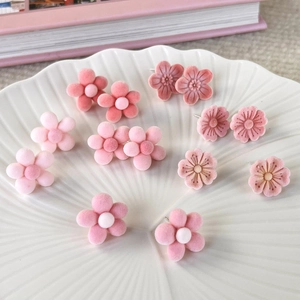 Sweet pink flocked flower stud earrings set displayed on a white ceramic shell tray