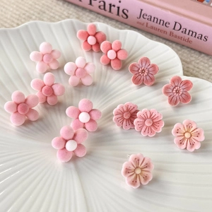 Handmade pink flocked flower stud earrings set displayed in a white textured shell bowl