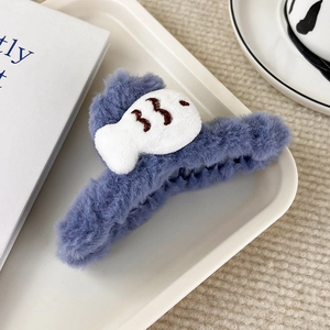 Dettaglio della morbida clip per capelli in peluche blu con design a pesce bianco