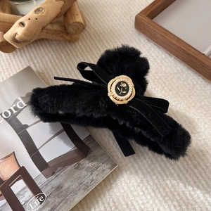 Detail view of plush hair claw clip with black velvet bow and pearl rose embellishment