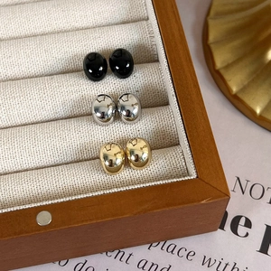 Three pairs of minimalist bean-shaped stud earrings in black, silver, and gold finish