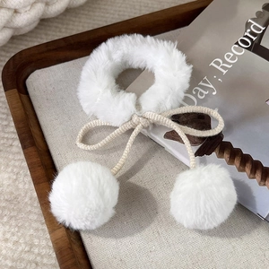 Dettaglio elastico per capelli in peluche bianco con fiocco e doppi pompon morbidi