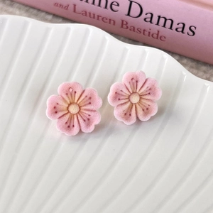 Close-up detail of soft pink flocked flower earrings with velvet petals and elegant style