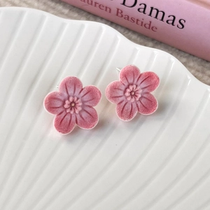 Macro view of pink velvet flower earrings with delicate petals and soft flocking texture