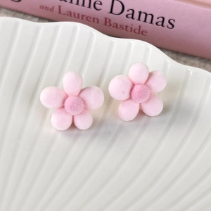 Close-up of pink flocked flower earrings with soft velvet texture and floral details