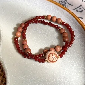 Bracelet double couche en agate rouge et bois avec un pendentif doré caractère Fu