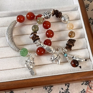 Macro detail of ethnic beaded bracelets with agate stones and silver elephant charms