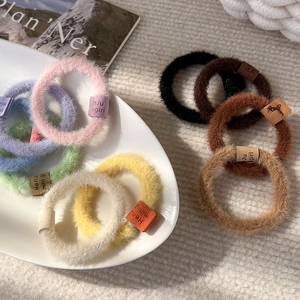 Plush Maillard style hair scrunchies with leather tags in various soft warm colors