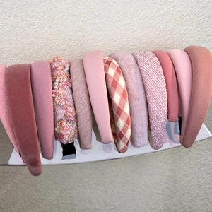 Close-up of pink headbands with velvet, knit and tweed textures on a display stand