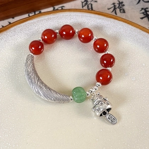 Detail of beaded bracelet with red agate, green jade, and vintage silver lucky cat charm