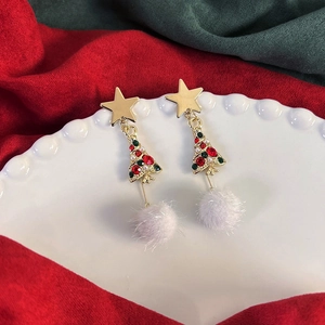 Dettaglio orecchini ad albero di Natale con pon pon bianco e perno a stella oro