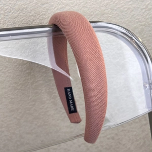 Detail of pink padded sponge headband with knitted texture and Hand Made label