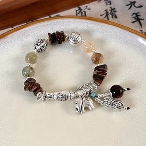 Close-up of ethnic beaded bracelet with silver elephant charm and natural stone beads