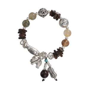 Ethnic style beaded bracelet with silver elephant and fish charms on white background