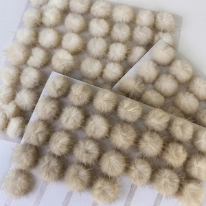 Close-up of fluffy cream plush star earring components on a white display card