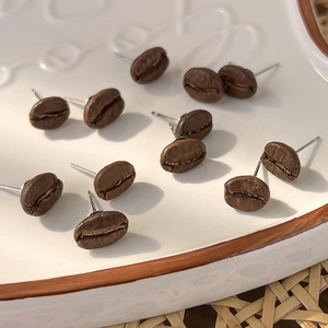 Handmade coffee bean stud earrings with realistic brown texture on a white ceramic tray