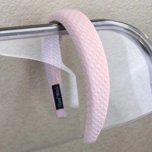 Detail of pink padded headband with honeycomb texture fabric and Hand Made label