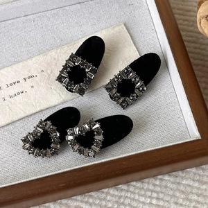 Detail of four-piece velvet hair clips set with grey rhinestones in heart and square shapes