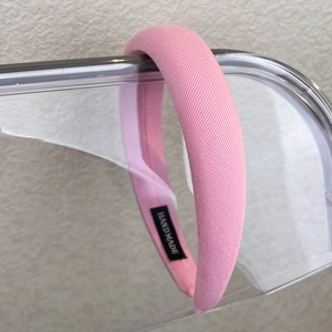 Detail of handmade pink padded headband featuring twill fabric and interior label