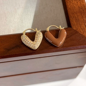 Vue macro de boucles d'oreilles cœur en V plaquées or avec zircons et émail marron