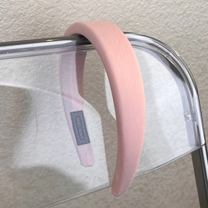 Close-up of pink padded sponge headband with handmade label and soft woven texture