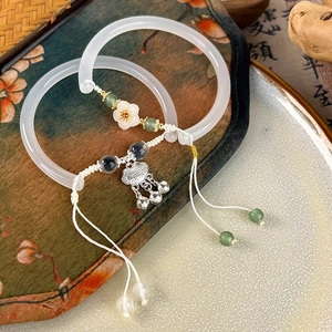 Close-up of vintage white resin floral bracelet with traditional silver lock charm