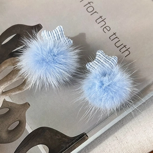 Detailed view of light blue plush star earrings with soft faux fur and striped fabric
