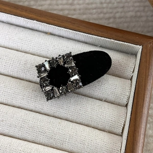Detail view of a luxury black velvet square hair clip with sparkling grey rhinestones