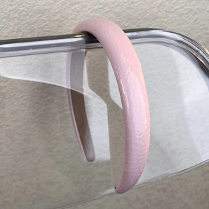 Detail of pink padded sponge headband featuring shiny faux leather and soft grey velvet lining