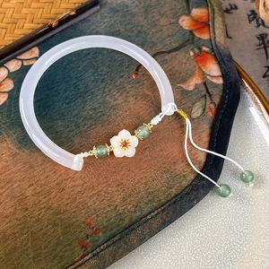 Close-up of a resin flower safety lock bracelet on a traditional Chinese silk fan