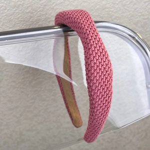 Close-up of pink knitted headband with thick woven texture and non-slip lining