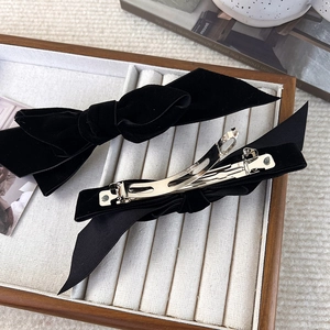 Detail of elegant black velvet bow hair clips with silver metal spring clip fasteners