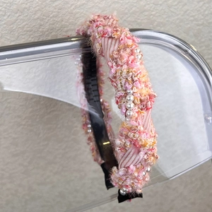 Close-up of pink tweed headband with white pearls, gold beads, and non-slip inner teeth