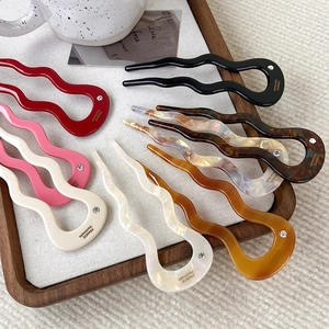 Elegant wavy U-shaped acetate hair pins in various colors with small rhinestone accents