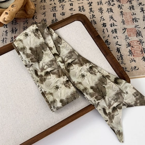Macro detail of silk-like Twilly ribbon with retro ink floral pattern on a wooden tray