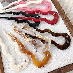 Close-up of acetic acid wave hair forks with rhinestones and handmade branding details