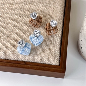 Detail showing tweed fabric heart earrings with crystal zircons in a display tray