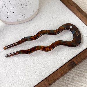 U-shaped tortoiseshell acetate hair pin with wave design and single rhinestone detail