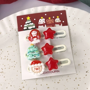 Vue détaillée de barrettes de Noël avec motifs Père Noël et sapin sur support